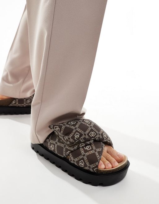 FhyzicsShops DESIGN – Brązowe bufiaste sandały ze skrzyżowanymi paskami ze wzorem z monogramem i czarną podeszwą