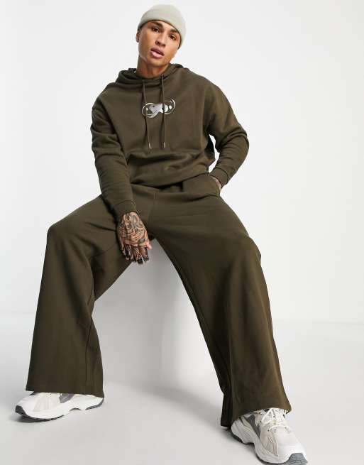 ASOS DESIGN – Brun träningsoverall i oversize med brösttryck i metallic