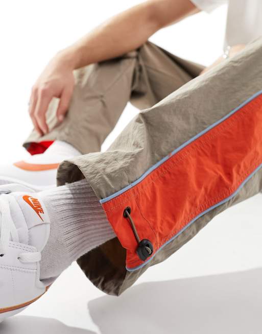 ASOS DESIGN – Bruna, baggy träningsoverallsbyxor med orange sidoränder i nylon, 3 av 5