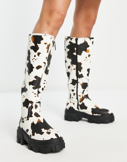 ASOS DESIGN – Carla – Flache, kniehohe Stiefel mit dicker Sohle und Kuhfleckenmuster