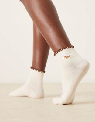 ASOS DESIGN - Chaussettes avec bord à volants et broderie teckel - Crème-Blanc