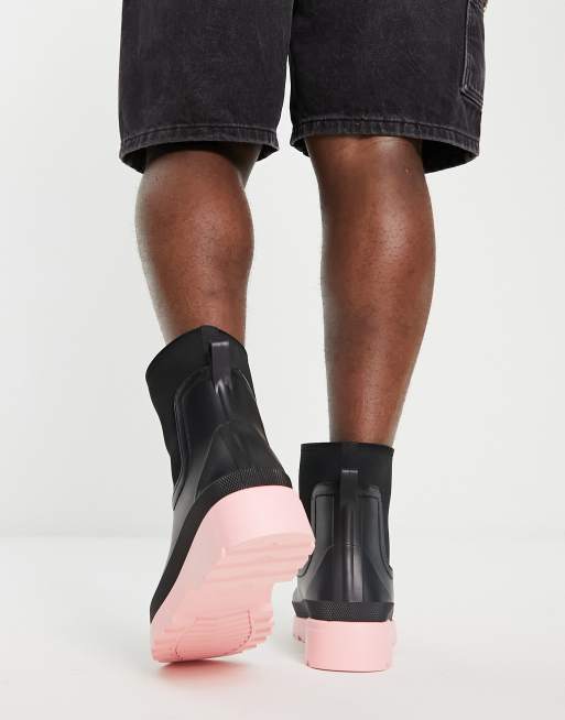 ASOS DESIGN chelsea wellington boots in black with pink contrast sole