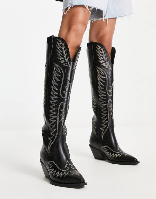 Black cowboy boots store with white stitching