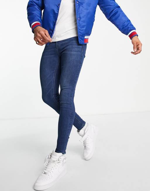 ASOS DESIGN – Ciemnoniebieskie jeansy typu spray on z denimu power stretch z efektem sprania
