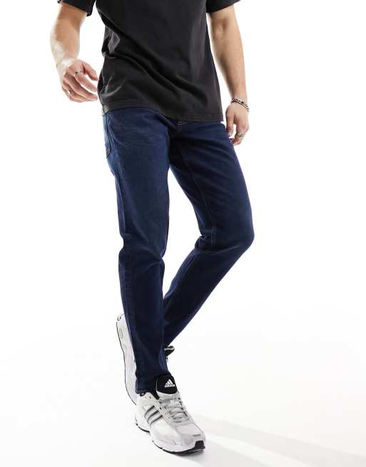 ASOS DESIGN - Ciemnoniebieskie jeansy ze spranego denimu ze stretchem o fasonie ze zwężanymi nogawkami