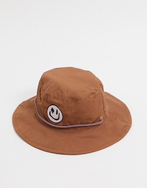 ASOS DESIGN co-ord bucket hat in brown with face logo
