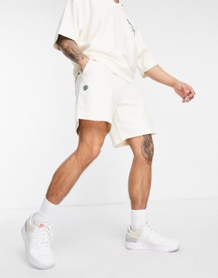 ASOS DESIGN co-ord oversized jersey shorts in beige with wellness embroidery