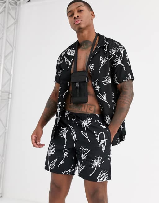 ASOS DESIGN coord swim shorts in black with hand drawn floral print in