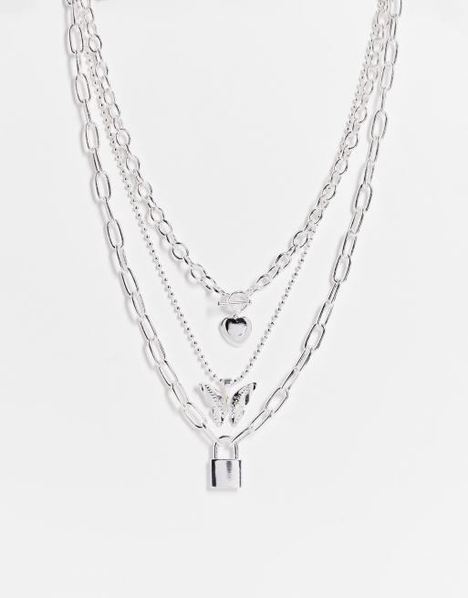 ASOS DESIGN - Collana multifilo color argento con ciondoli a farfalla e lucchetto in stile anni '90