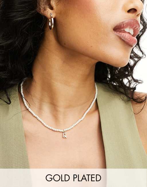 ASOS DESIGN - Collana placcata oro 14 ct con segno zodiacale del Leone e perle di vetro sintetiche in confezione regalo