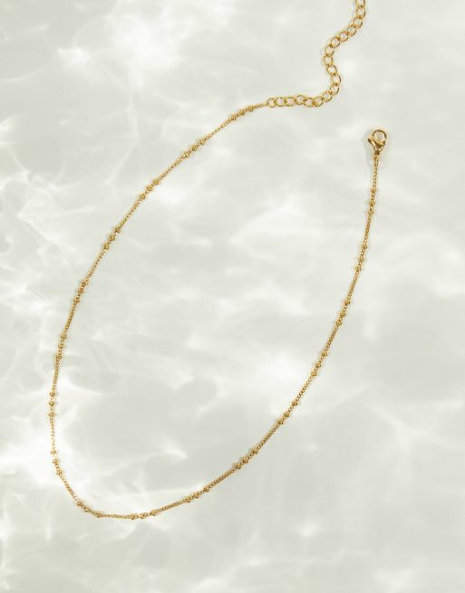 ASOS DESIGN - Collarino in acciaio inossidabile resistente all'acqua dorato con design a pallini tripli