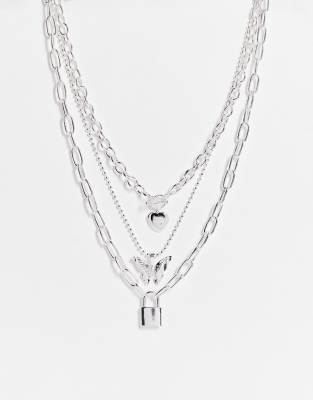 ASOS DESIGN - Collier chaîne multi-rangs style années 90 avec pendentif cadenas, cœur et papillon - Argenté
