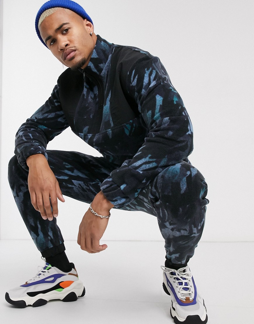 ASOS DESIGN - Combi-set, smalle fleece joggingbroek met camouflageprint en nylon inzetstukken-Blauw