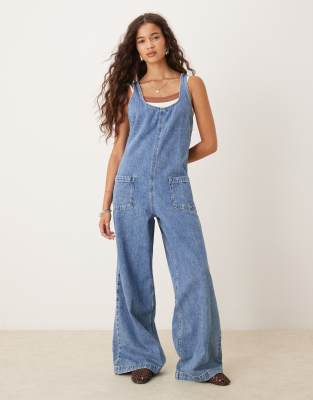 ASOS DESIGN - Combinaison salopette en jean avec dos croisé - Bleu moyen délavé