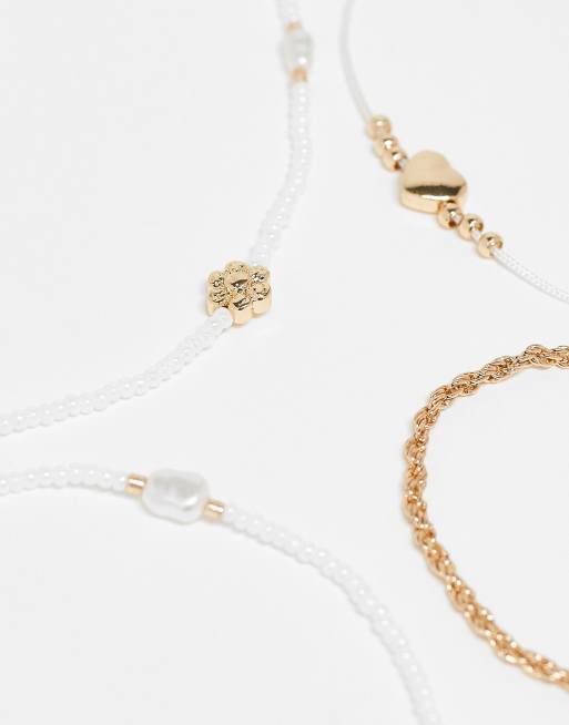 ASOS DESIGN - Confezione da 4 cavigliere dorate con perline, perle sintetiche e ciondoli a forma di cuore, 2 di 3