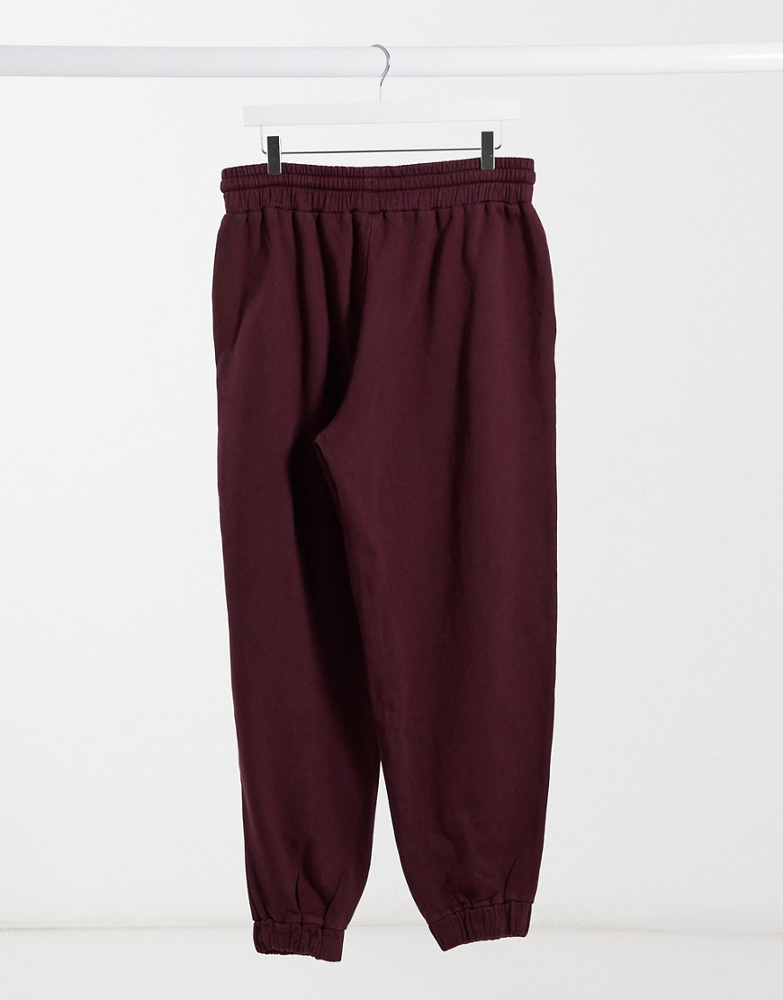 ASOS DESIGN coordinating super-oversized sweatpants with toggle hem in washed burgundy-Red