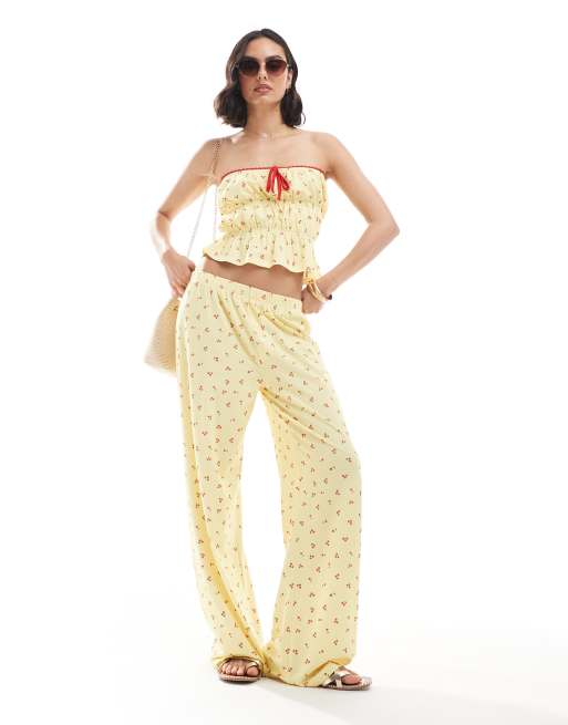 ASOS DESIGN - Coordinato con fascia arricciata e pantaloni color latticello con stampa di ciliegie