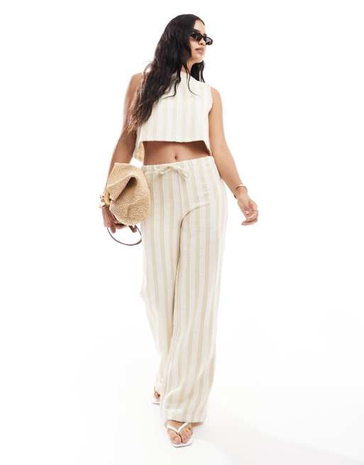 ASOS DESIGN - Coordinato con top senza maniche e pantaloni a vita bassa e fondo ampio color cammello a righe