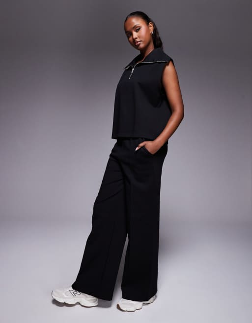 ASOS DESIGN - Coordinato in interlock nero con top senza maniche con zip corta e pantaloni