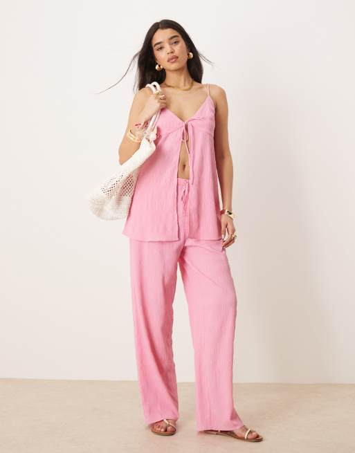 ASOS DESIGN - Coordinato taglio lungo color rosa acceso composto da canottiera allacciata sul davanti e pantaloni a zampa