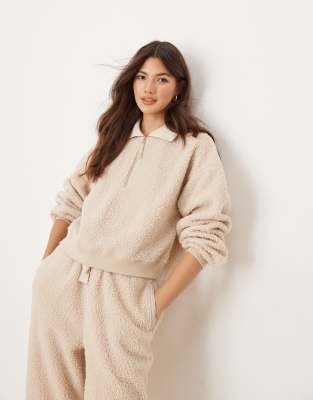 ASOS DESIGN - Cremefarbenes Lounge-Set aus Teddyfell mit schmal zulaufender Hose und Sweatshirt mit Reißverschluss am Kr...