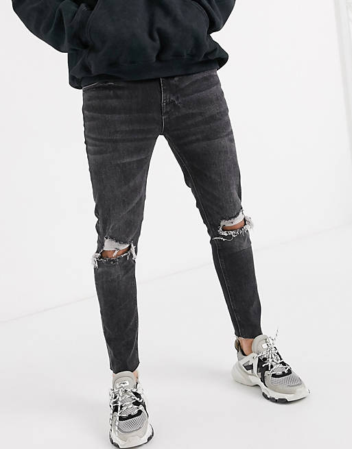 ASOS DESIGN cropped skinny jeans in washed black with raw hem and knee ...