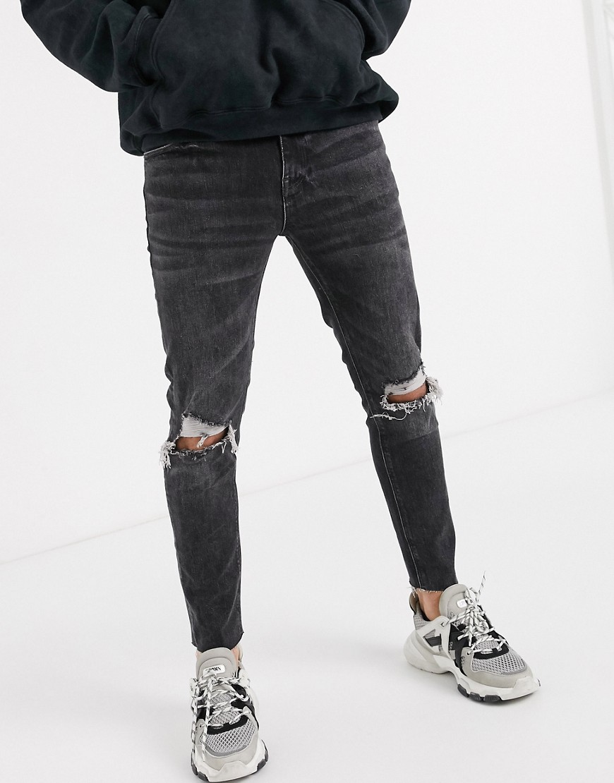ASOS DESIGN - Cropped skinny jeans met onafgewerkte zoom en kniescheuren in zwart met wassing