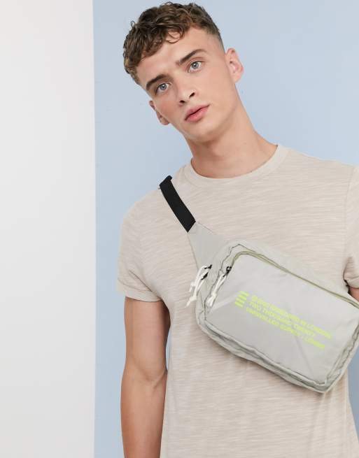 ASOS DESIGN cross body bum bag in beige with text print ASOS