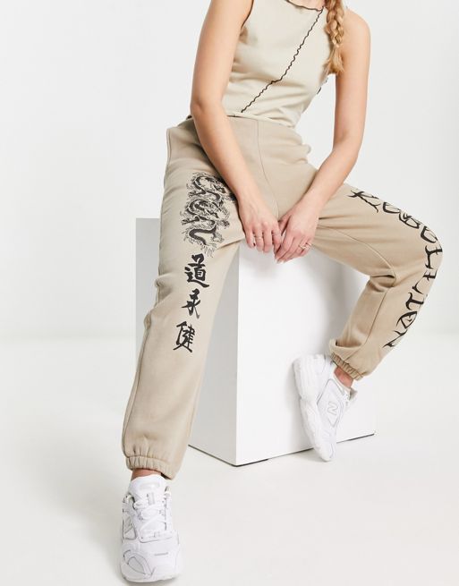 ASOS DESIGN cuffed jogger with dragon graphic in stone