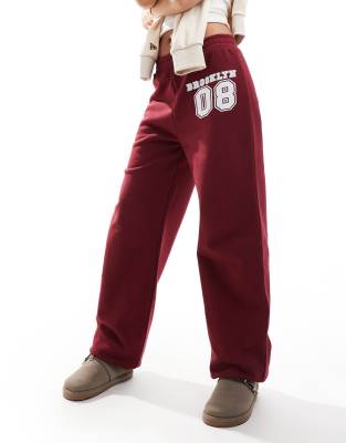 ASOS DESIGN cuffed jogger with number applique in burgundy-Red