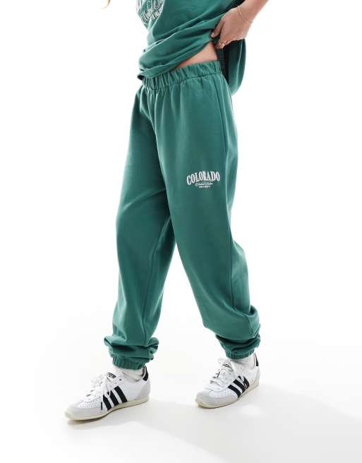 ASOS DESIGN cuffed trackies with Colorado graphic green | ASOS