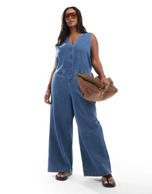 ASOS DESIGN Curve - Ärmelloser Jeans-Jumpsuit in mittelblauer Waschung mit lockerem Schnitt