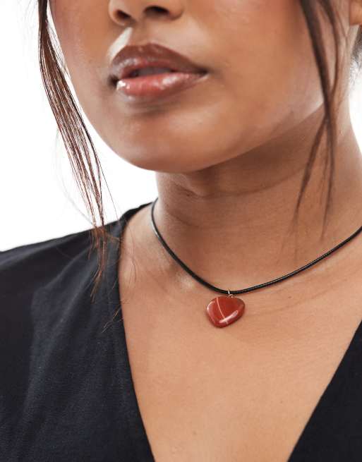 A plus-size, black cord necklace with a red heart pendant