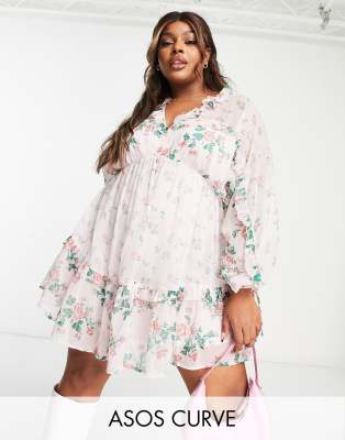 ASOS DESIGN Curve - Mini-Skater-Kleid mit Blumenprint in Rosa, V-Ausschnitt vorne und hinten und Rüschen-Bunt