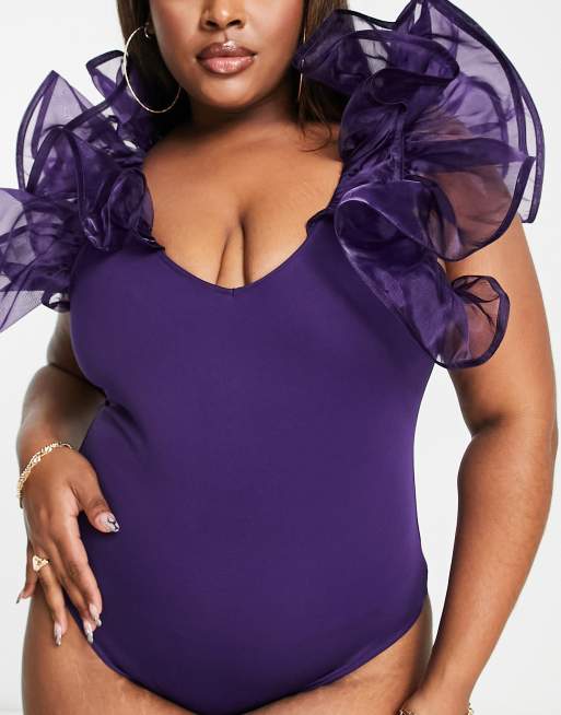 Plus Size Model with Large Breasts in Purple Bodysuit on Pink