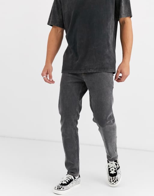 ASOS DESIGN - Czarne jeansy ze stretchem o fasonie ze zwężanymi nogawkami z efektem sprania