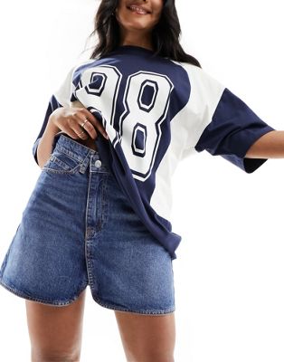 denim mini skirt with cross front waist in mid wash blue