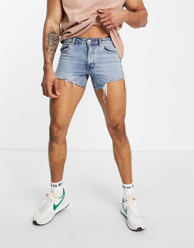 ASOS DESIGN denim shorts in 90s mid wash with rip detail and raw hem in shorter length