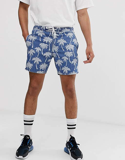 ASOS DESIGN denim shorts in mid wash blue palm print with elasticated waist in shorter length