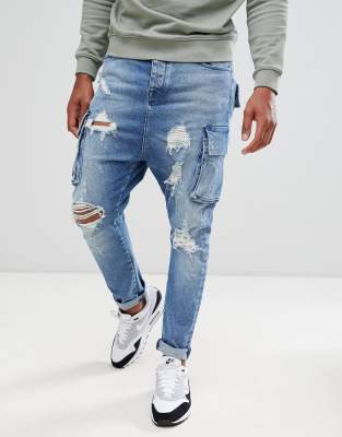 ASOS DESIGN drop crotch jeans in mid wash blue with cargo pockets and rips