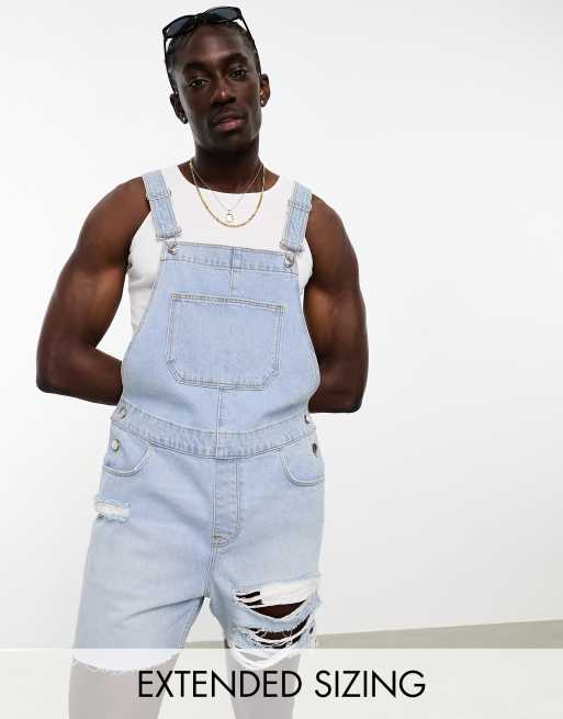 ASOS DESIGN dungarees in light wash blue with heavy rips in