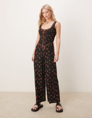 ASOS DESIGN - Durchgeknöpfter Jumpsuit aus gesponnenem Stoff in Schwarz mit Spitzenborte und Kirschmuster-Bunt