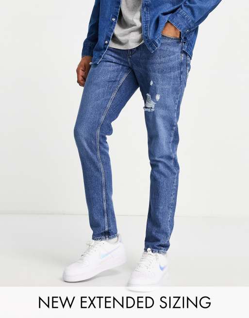 ASOS DESIGN - Elastische slim-fit jeans met scheuren in donkerblauwe wassing