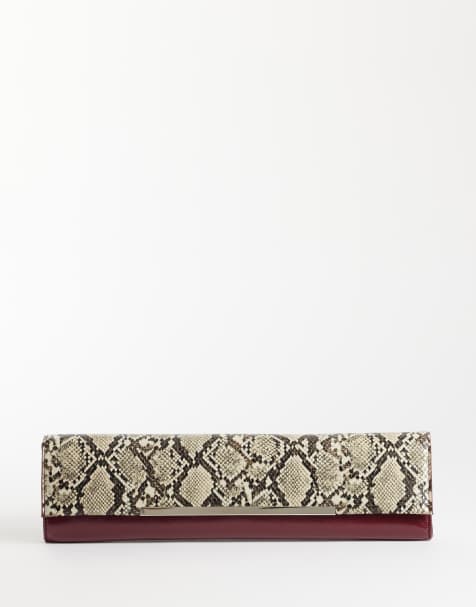 ASOS DESIGN elongated clutch in snake and burgundy with metal bar detail - view 1