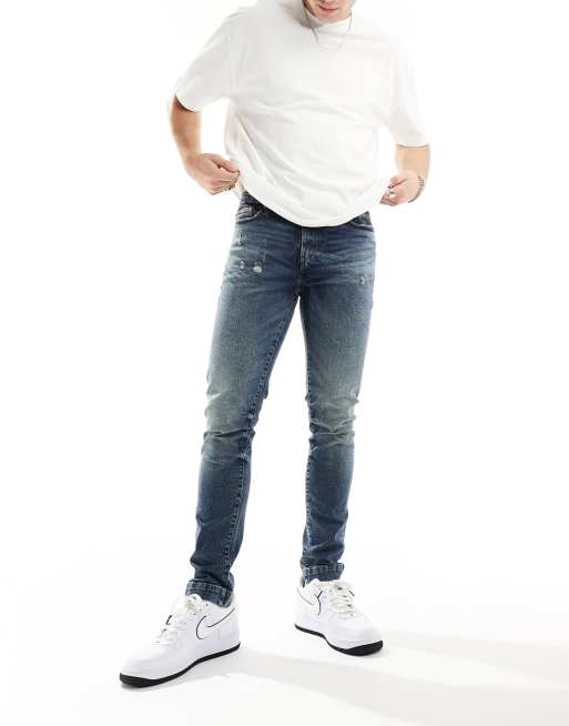 ASOS DESIGN – Eng geschnittene Jeans in dunkelblauer Waschung mit Abreibungen