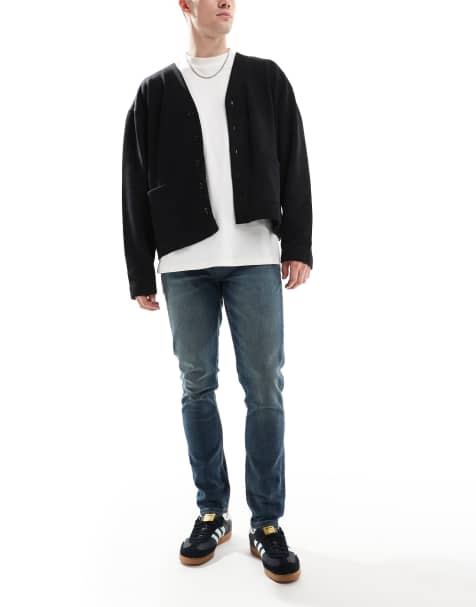 ASOS DESIGN – Eng geschnittene Jeans in gelb getönter, dunkelblauer Waschung - view 1