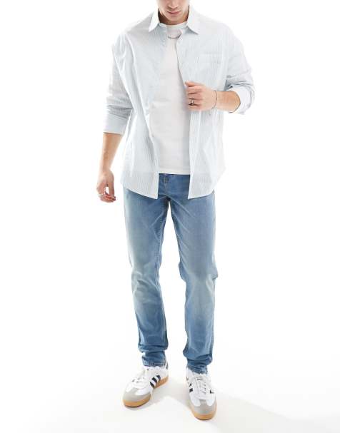 ASOS DESIGN – Eng geschnittene Jeans in mittelblauer Waschung mit gelber Tönung - view 1