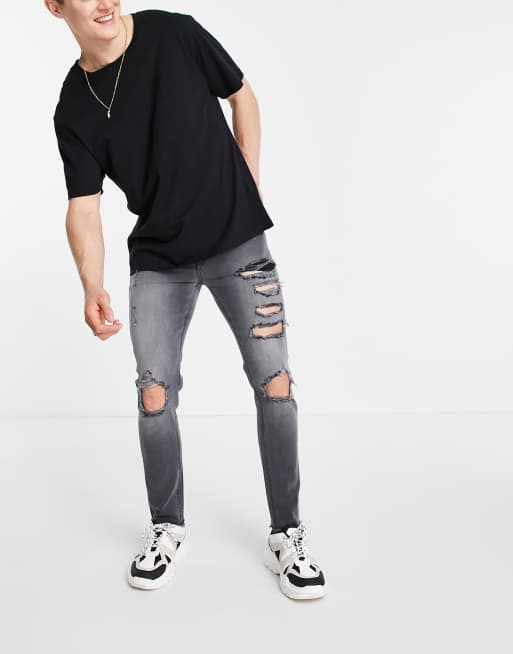 ASOS DESIGN – Eng geschnittene Jeans mit starken Rissen und unversäubertem Saum in verwaschenem Schwarz