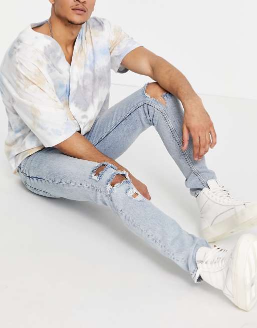 ASOS DESIGN – Enge Jeans in hellblauer Vintage-Waschung mit großen Rissen