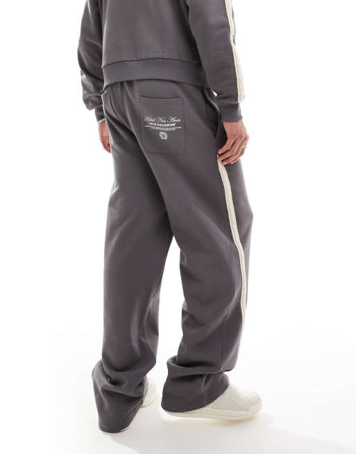 ASOS DESIGN extreme wide leg trackies with slanted side tape with text print in charcoal, 5 of 5